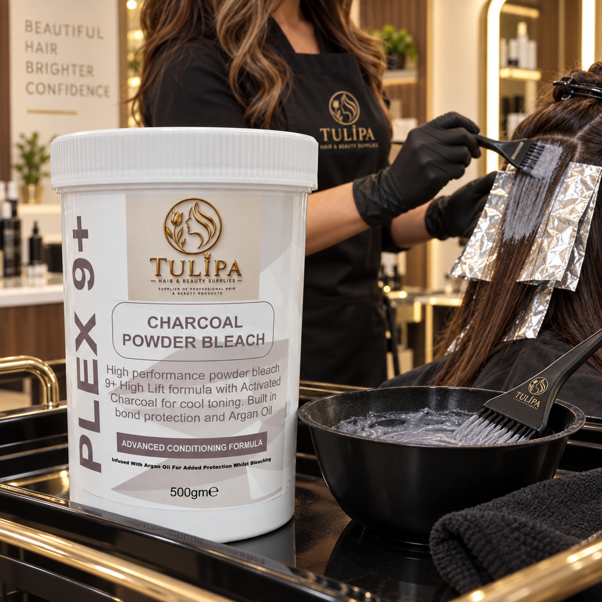 Hairdresser applying Tulipa PLEX 9+ Charcoal Powder Bleach during a professional foil-highlighting service